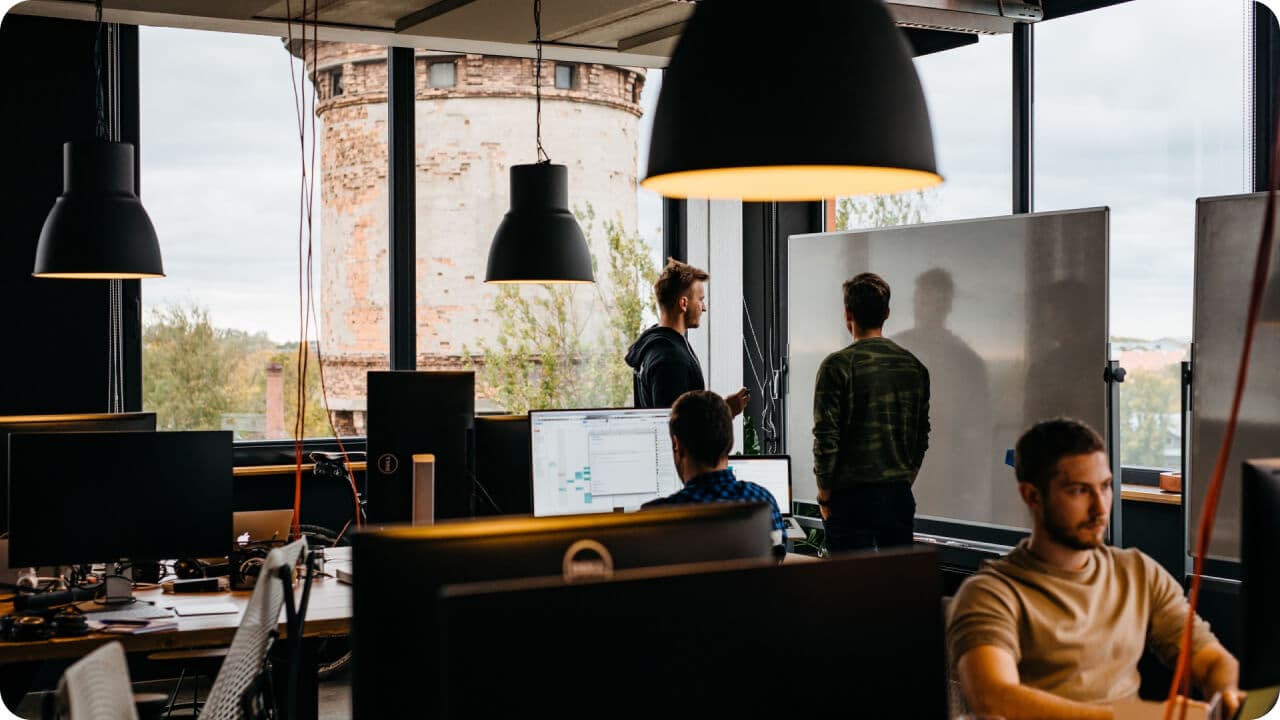 People working and brainstorming in front of a white-board in office with a nice view