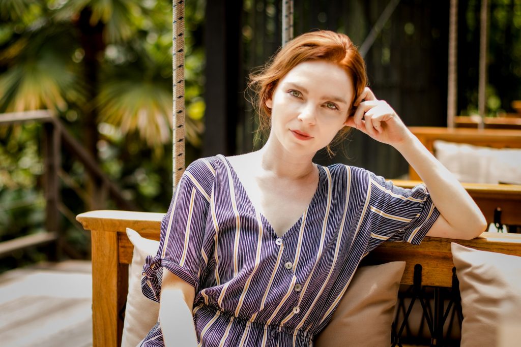 Professional woman sitting down outside while casually looking into the camera.