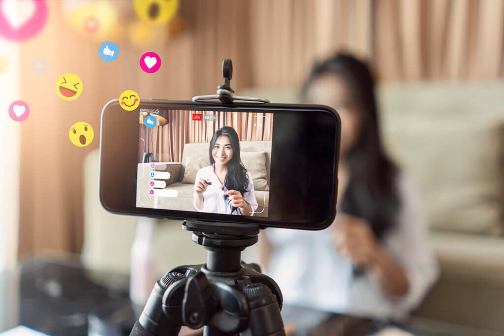 Social Commerce businesswoman using live video interaction with customers on camera device, vlogging and selling make up products